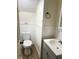 Bathroom featuring a toilet, a sink with vanity, and a stylish towel ring, blending functionality with style at 4850 E University Ave, Indianapolis, IN 46201