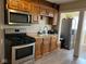 Functional kitchen featuring stainless steel appliances and wooden cabinetry at 4850 E University Ave, Indianapolis, IN 46201