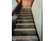 Carpeted stairway with wooden banister, enhanced with tasteful holiday-themed accents, connecting floors with grace at 4850 E University Ave, Indianapolis, IN 46201