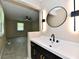 Bathroom features a sleek black vanity, mirror, modern lights, and an open view of the living space at 504 W Gold Creek Rd, Mooresville, IN 46158