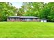 Charming brick home with a lush green lawn, mature trees, and a detached two-car garage at 504 W Gold Creek Rd, Mooresville, IN 46158