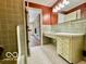 Classic bathroom featuring green tile and a sink and mirror at 5222 Nob Ln, Indianapolis, IN 46226