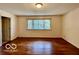 A large room featuring a window, hardwood floors, and neutral paint at 5222 Nob Ln, Indianapolis, IN 46226