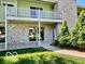 Inviting home showcasing a stone facade, second-story balcony, and lush landscaping at 5222 Nob Ln, Indianapolis, IN 46226