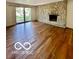 Bright living room boasts hardwood floors, a stone fireplace, and a sliding glass door at 5222 Nob Ln, Indianapolis, IN 46226