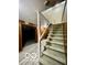 Carpeted stairs lead to a lower level with wood paneled walls and finished vinyl floors at 5222 Nob Ln, Indianapolis, IN 46226