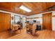 Spacious office featuring wood paneled walls, multiple windows, and a desk area with a black office chair at 5330 W 56Th St, Indianapolis, IN 46254