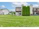 Well-maintained backyard with lush lawn, towering evergreens, and patio area at 5372 Bay Harbor Dr, Indianapolis, IN 46254