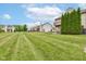 Sprawling backyard with meticulously mowed lawn, mature trees, and inviting patio at 5372 Bay Harbor Dr, Indianapolis, IN 46254
