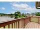 A serene lake view from a private wooden balcony, with trees and greenery in the background at 5372 Bay Harbor Dr, Indianapolis, IN 46254