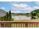Scenic view of a lake from a wooden balcony with lush greenery and trees surrounding the water at 5372 Bay Harbor Dr, Indianapolis, IN 46254
