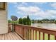 A wooden balcony overlooking a tranquil lake, with a satellite dish and trees in the background at 5372 Bay Harbor Dr, Indianapolis, IN 46254