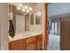 Bright bathroom with a white countertop, wooden cabinets, and a view into the main bedroom at 5372 Bay Harbor Dr, Indianapolis, IN 46254