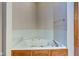 Corner bathtub with a tiled surround and a chrome faucet set against neutral walls at 5372 Bay Harbor Dr, Indianapolis, IN 46254
