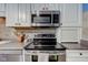 Close-up of modern stainless steel appliances, including a microwave and oven, set against a tiled backsplash at 5372 Bay Harbor Dr, Indianapolis, IN 46254
