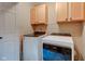 Functional laundry room features a side-by-side washer and dryer and ample overhead cabinet space at 5372 Bay Harbor Dr, Indianapolis, IN 46254