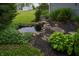 Landscaped backyard featuring a small pond with rock edging and lush foliage at 5388 W Hazelrigg Rd, Thorntown, IN 46071