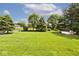 Backyard with large lawn, mature trees, storage shed and chain link fence at 551 Windward Ln, Plainfield, IN 46168