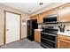Kitchen featuring oak cabinets, black appliances and a door leading to the outside at 551 Windward Ln, Plainfield, IN 46168