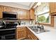 Functional kitchen with stainless steel appliances and natural wood cabinets at 551 Windward Ln, Plainfield, IN 46168