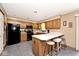 Efficient kitchen layout with breakfast bar, black appliances and ample cabinet space at 551 Windward Ln, Plainfield, IN 46168