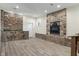 A finished basement with a stone fireplace, wood-look floors, and stone accent walls at 6348 W 750 N, McCordsville, IN 46055