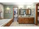 Bathroom with double vanity, soaking tub, and access to closet at 6575 Robin Hood Dr, Indianapolis, IN 46227