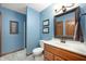 Comfortable bathroom featuring blue walls, tile floors, and a wooden vanity at 6575 Robin Hood Dr, Indianapolis, IN 46227