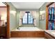 Bathroom featuring a soaking tub, wooden cabinets, and natural light at 6575 Robin Hood Dr, Indianapolis, IN 46227