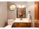Charming powder room with octagonal window, wooden cabinets, and cream countertops at 6575 Robin Hood Dr, Indianapolis, IN 46227