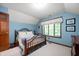 Light-filled bedroom with a wooden bed, window, and blue walls at 6575 Robin Hood Dr, Indianapolis, IN 46227