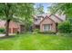 Attractive two-story brick home with manicured lawn, mature trees, and attached two-car garage at 6575 Robin Hood Dr, Indianapolis, IN 46227