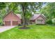 Charming brick home featuring a two-car garage and a lush green lawn at 6575 Robin Hood Dr, Indianapolis, IN 46227
