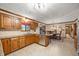 Traditional-style kitchen featuring wooden cabinets, granite countertops, and a dining area with tile flooring at 6575 Robin Hood Dr, Indianapolis, IN 46227