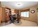 Home office with built-in bookshelf, desk, and natural light from window at 6575 Robin Hood Dr, Indianapolis, IN 46227