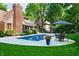 Swimming pool surrounded by a patio area, manicured lawn, and mature trees for a relaxing outdoor space at 6575 Robin Hood Dr, Indianapolis, IN 46227