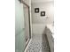Bathroom showcases a glass door shower, textured wall and patterned gray floors at 6604 Heritage Hill Dr, Indianapolis, IN 46237