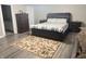Bedroom with a bed, dresser, and neutral walls with wood-look floors at 6604 Heritage Hill Dr, Indianapolis, IN 46237