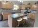 Updated kitchen features gray granite countertops, wooden cabinetry, a center island and stainless steel appliances at 6604 Heritage Hill Dr, Indianapolis, IN 46237