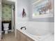 Bright bathroom featuring a soaking tub with white tile surround and decorative accent tiling at 6897 Abercon Trl, Noblesville, IN 46062