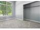 Cozy bedroom with neutral carpeting, a bright window, and an empty closet space at 6897 Abercon Trl, Noblesville, IN 46062