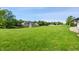 Expansive backyard view featuring lush green grass, a pond with a fountain, and several homes at 6897 Abercon Trl, Noblesville, IN 46062