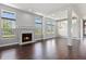 Spacious living room featuring a fireplace, large windows, dark hardwood floors, and elegant lighting at 6897 Abercon Trl, Noblesville, IN 46062