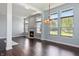 Bright living room boasts a cozy fireplace, dark hardwood floors, and an elegant chandelier, perfect for entertaining at 6897 Abercon Trl, Noblesville, IN 46062