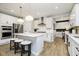 Modern kitchen with white cabinets, stainless steel appliances, island with breakfast bar, and wood-look floors at 7242 Barrett Dr, Brownsburg, IN 46112