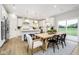 Open concept kitchen with white cabinetry, stainless steel appliances, and dining area with backyard access at 7242 Barrett Dr, Brownsburg, IN 46112