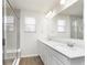 Bathroom with walk-in shower, double vanity with white cabinets, and large mirror at 7318 Shroyer Way, Noblesville, IN 46062