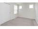 Bedroom featuring neutral carpet, three bright windows, and a white door at 7318 Shroyer Way, Noblesville, IN 46062