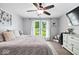 Cozy bedroom with large window, ceiling fan, dresser, and comfortable bedding at 7345 Monon Cir, Indianapolis, IN 46256