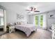 Serene bedroom with neutral tones, ceiling fan, large window, and decorative accents at 7345 Monon Cir, Indianapolis, IN 46256